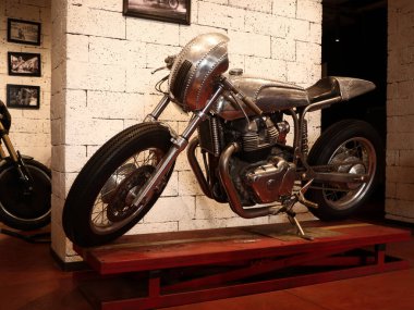 Eski bir retro motosiklet müşterileri ve hayranları cezbetmek için bir kahve dükkanında sergileniyordu..