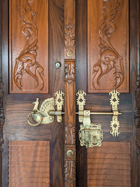 a highly detailed handcrafted golden door handle and lock on a vintage wooden door