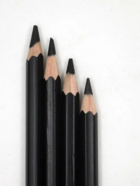 白い背景に斜面に配置された黒いスケッチ鉛筆 — ストック写真