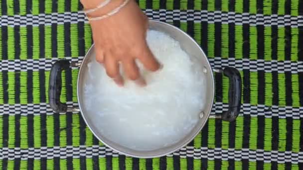 角のある女性の手を閉じて水で満たされたスチール製のボウルに白い米粒を洗って掃除する — ストック動画
