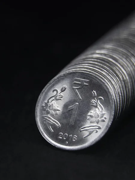 stock image closeup shot of shiny silver one or 1 rupee coin of india arranged in a straight row isolated in a black background