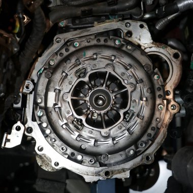 closeup of a full clutch assembly mounted on the engine transmission line of a vehicle brought for regular service in the workshop clipart