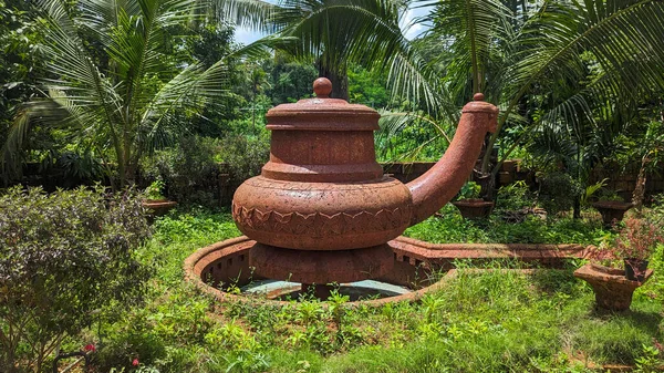 a giant water pot jar sculpture carved on red brick stones as a classic outdoor garden attraction