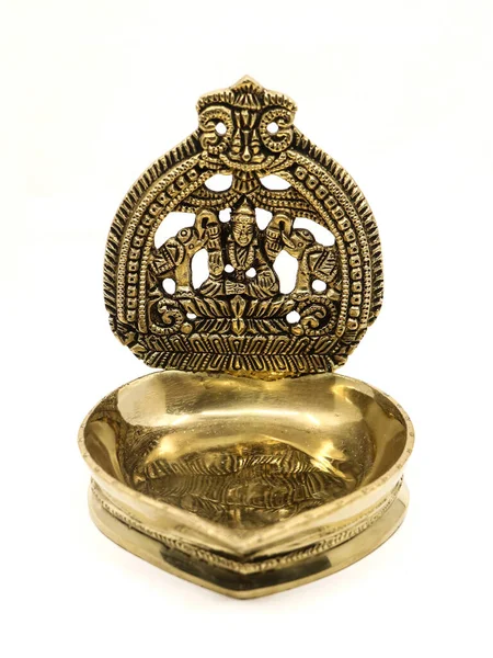 Eski bir pirinç kamatchi diya yağ lambası. Beyaz arka planda izole edilmiş aarti pooja için geleneksel dini ayinlerde kullanılan bir Hindu tanrısı oyması.