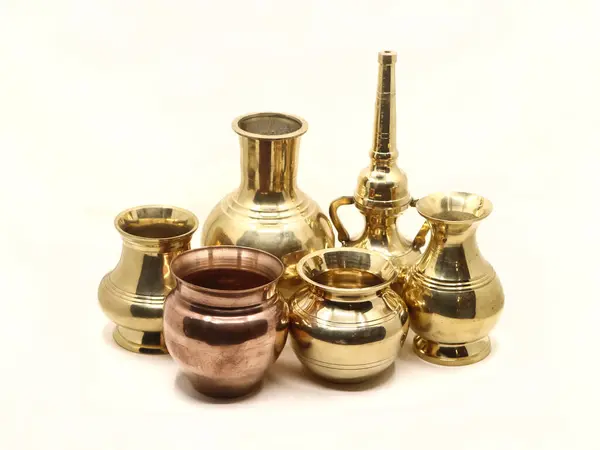 Beyaz arka planda izole edilmiş metal antika vazo, tencere ve su kabı koleksiyonu.