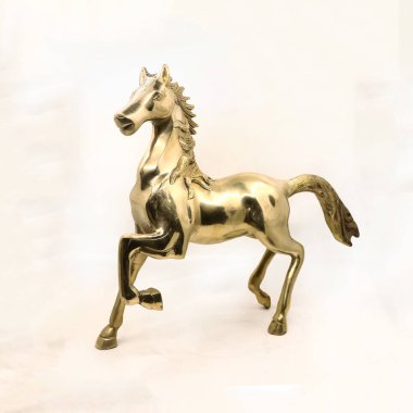 Beyaz arka planda izole edilmiş antika dekorlar satan bir hediyelik eşya dükkanından altın oyulmuş bir at aygırının lüks heykeli.