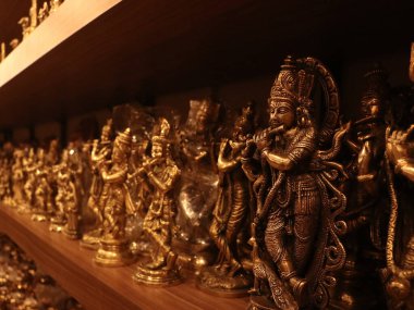 El yapımı Lord Krishna tapınağın yakınındaki dini bir hediyelik eşya dükkanında sergilenmek üzere saklanmış flüt putları çalıyor.