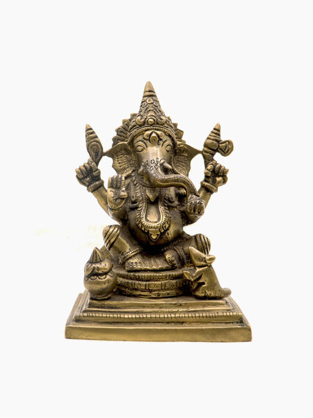 front view of sitting ganesh with four hands, brass statue with intricate details and decorative carvings isolated in a white background 