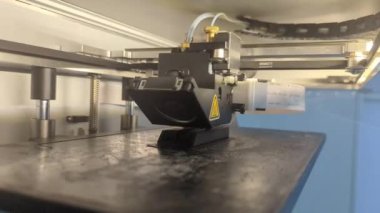 Bir fabrikada etkin olarak üretim parçaları basan 3D yazıcı, hassasiyet ve verimlilikle bileşenler üretiyor.