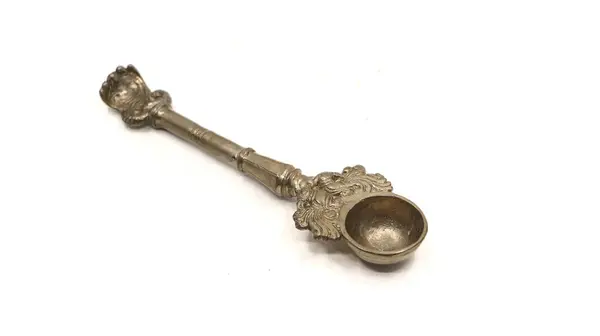 Beyaz arka planda izole edilmiş pooja ritüelleri için kullanılan el yapımı bronz kaşık.