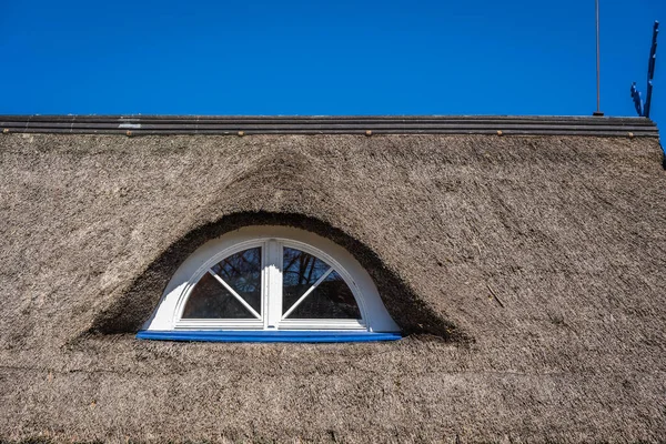 Yarı dairesel çatı penceresi olan eski bir saman ya da kamış çatısının parçası.