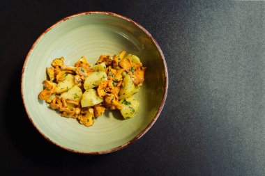 Kızarmış mantarlı bir kâse, haşlanmış patates, maydanoz ve dereotlu. Organik, mevsimsel ve yerel ürünlerle taze vejetaryen yemeği.