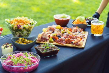 Garson sofrayı mezelerle birlikte bahçedeki açık büfeye koyar..