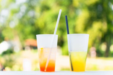 Parlak yaz kokteylleri turuncu ve sarı yaz yeşilliğinin bulanık arka planında.