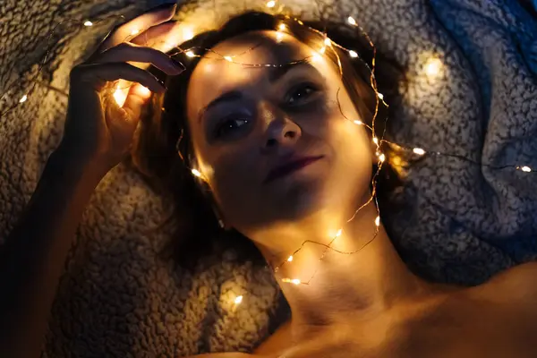 Close-up of a womans face with festive lights
