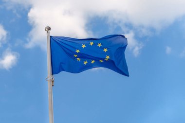 Avrupa Birliği bayrağı, bulutlu mavi gökyüzünün arka planında dalgalanır