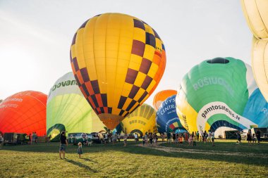 Vilnius, Litvanya - 08 05 2022: Vilnius 'ta sıcak hava balonları. Kalkıştan önce yerde çok renkli sıcak hava balonları var. Sahada bir sürü balon var.
