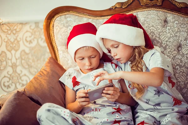 Μικρός Αδερφός Και Αδελφή Καπέλα Και Τις Χριστουγεννιάτικες Πιτζάμες Κάθονται — Φωτογραφία Αρχείου