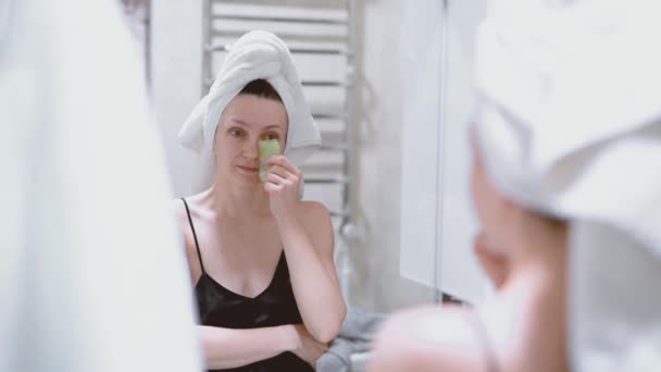 Kadın Guaj Kazıyıcıyla Yüz Masajı Yapıyor Aynaya Bakıyor Gecelik Giyiyor — Stok video