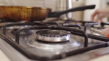 Doğal gaz sobasını çakmakla yakmak ve ertelemek. Mavi alevlerle yanan doğal gaz. gaz ocağı pişirme ve AB gaz krizi. 