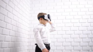 Çocuk VR kulaklıkla oyun oynuyor. Evde iyi vakit geçiriyorum. Sanal gerçekliği izole etmek. VR kulaklık takan, elini hareket ettiren ve havaya dokunan bir çocuk. Dijital eğitim ya da sanal gerçeklik eğitimi. 