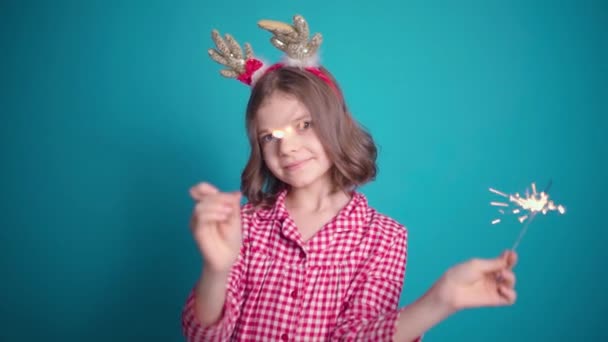 色の背景にカメラの前でキラキラと踊るパジャマ姿の可愛い女の子 クリスマスのコンセプト スローモーション — ストック動画