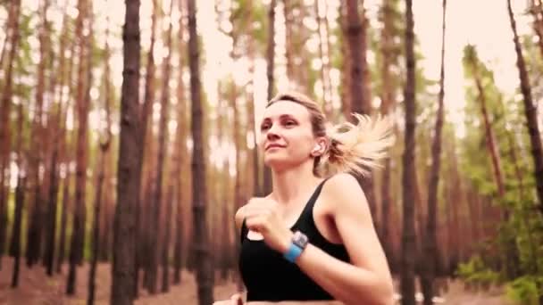 Beautiful Blonde Girl Running Forest While Wearing Fitness Clothes Headphones — Stock Video