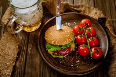 Ev yapımı sığır burger, bir bardak bira ve vişneli domates, gastro bar. Seçici Odaklanma 