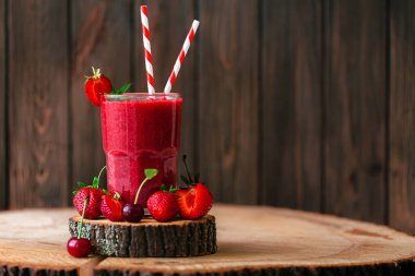 Taze meyve suyu ya da bardakta saman, taze çilek ve ahşap kirazlı smoothie. Seçici odaklanma. Vejetaryen yemeği. Sağlıklı yiyecekler. Vitamin yiyeceği. 