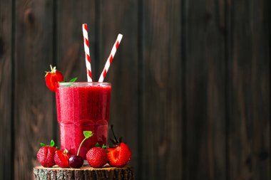 Taze çilek suyu ya da bardakta saman, taze çilek ve ahşap arka planda kirazlı smoothie. Seçici odaklanma. Vejetaryen yemeği. Sağlıklı yiyecekler. Vitamin yiyeceği. 