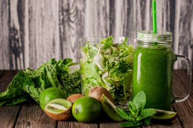 Front view of blended green smoothie in jar with fruit and vegetables on wood rustic table. selective focus. Healthy eating. Vitamin food 