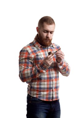 Portrait of handsome bearded redhead man in checked shirt who holds pipe isolated on white background. Copy Space 
