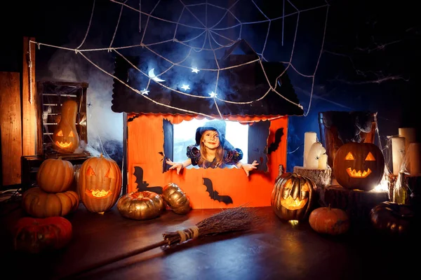 Cadı Kostümlü Küçük Tatlı Kız Sihirli Bir Karton Evin Penceresinden — Stok fotoğraf