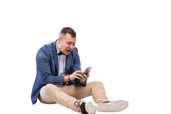 Geschokt Jonge Man Zoek Naar Een Smartphone Terwijl Zitten Vloer — Stockfoto