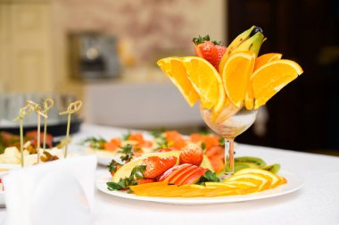 Meyve, et, abur cubur ve şamdanlı büfe masası.