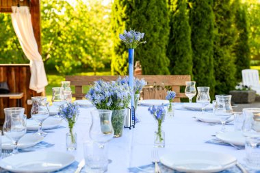 Masa dekoru mavinin tonlarında ve Avusturyalı Veronica çiçekleri