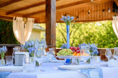 Masa dekoru mavinin tonlarında ve Avusturyalı Veronica çiçekleri