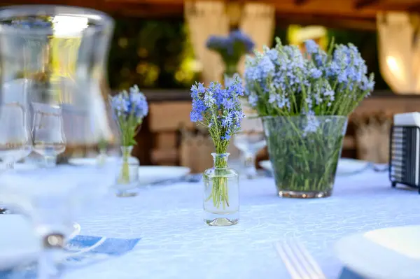 Masa dekoru mavinin tonlarında ve Avusturyalı Veronica çiçekleri
