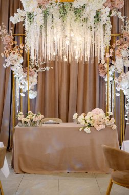 Bir restoranın tavanında çiçekli ve mumlu düğün süslemeleri.