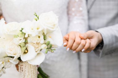 Gelin ve damat düğün buketi taşıyor..