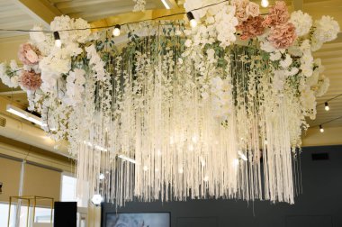 Bir sürü çiçeğin olduğu güzel bir düğün salonunun içi.