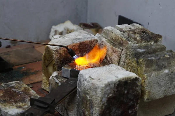 Unwanted silver is melted down in a crucible to be used in the next silversmithing project