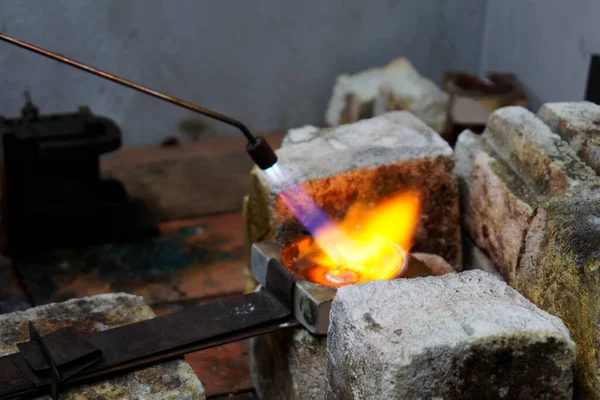 Flames burn brightly to melt unwanted silver down so it can be reused for casting.