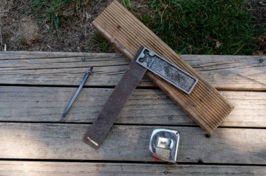 Aletler kullanılmayı bekliyor. Dik açı, mezura ve kalem almak için bir set karesi.