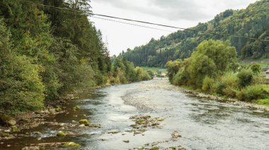 Dağlarda yeşil kıyıları olan bir nehir.