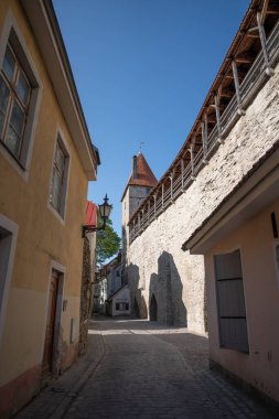 Tallinn 'in eski bir kasabasında şehir duvarı ve savunma kulesi olan dar bir cadde.