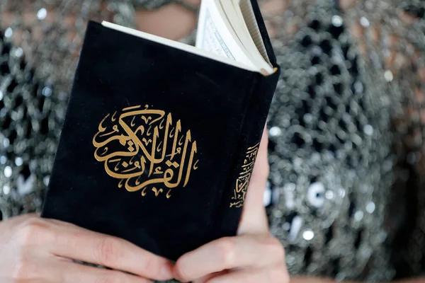 Woman reading the Noble Quran. Close-up.
