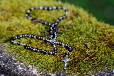 Rosary on an old stone with moss.  France. 
