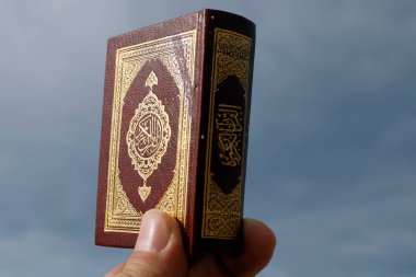Man with a small Quran. Close-up.