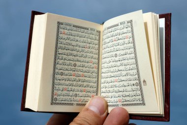 Man with a small Quran. Close-up.